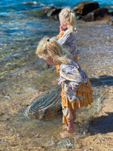 two young girls standing in lake water